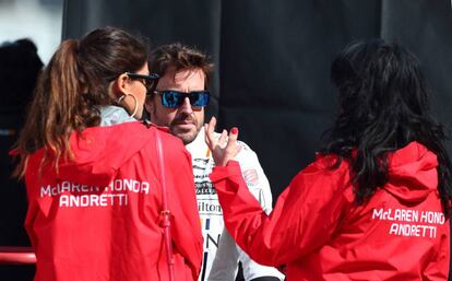 El piloto español Fernando Alonso conversa con dos mujeres.