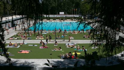 Vista de varias personas disfrutando de la piscina municipal de El Lago, en Casa de campo (Madrid) en julio de 2023.