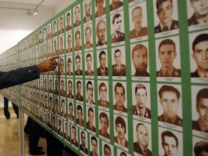Un agente se&ntilde;ala una foto en la exposici&oacute;n &#039;la Guardia Civil, escudo de la democracia frente al terrorismo&#039;, en Sevilla.
