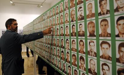 Un agente señala una foto en la exposición 'la Guardia Civil, escudo de la democracia frente al terrorismo', en Sevilla.