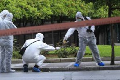 Artificieros recogen pruebas en el lugar donde hoy se ha producido la explosión de un coche bomba en el centro de Atenas (Grecia).