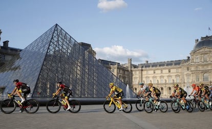 El colombiano Egan Bernal, en el centro, pasando por la pirámide del Museo del Louvre.