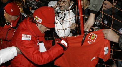 Fernando Alonso firmando autógrafos a los aficionados de Ferrari.