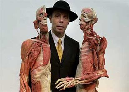 Gunther von Hagen posa entre dos cuerpos revestidos de material plástico que se exhiben en <i>Mundos corporales.</i>
