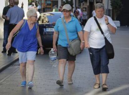 Los turistas que recorren Valencia, con garrafas de agua para aliviar las altas temperaturas.