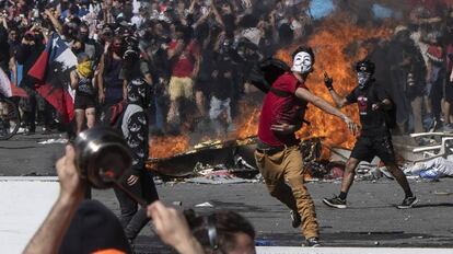 Un joven lanza piedras contra la policía durante una protesta en Santiago de Chile.
