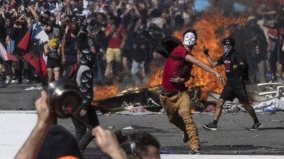 Un joven lanza piedras contra la policía durante una protesta en Santiago de Chile. 