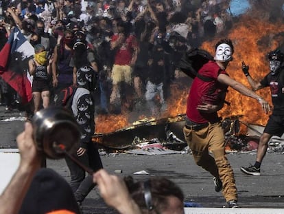 Un joven lanza piedras contra la policía durante una protesta en Santiago de Chile. 