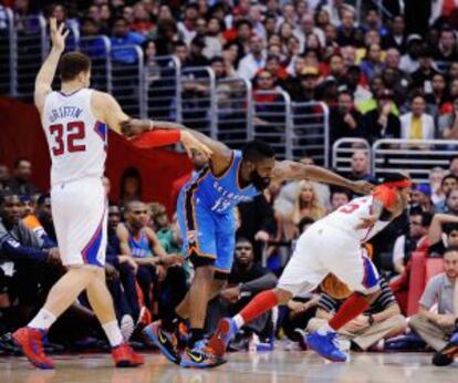 James Harden (centro) forcejea con Griffin mientras Williams se dirige a canasta.