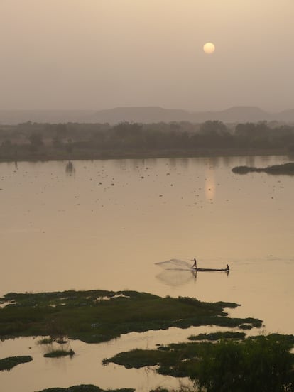 Un hombre suelta las redes para pescar al atardecer en el río Níger, en Niamey.