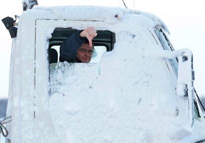 Un camionero gesticula ante la nieve que cubre toda su vehículi en una carretera de Edimburgo.