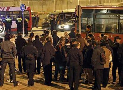 Piquetes y trabajadores esperan en la madrugada de ayer la salida de autobuses en Carabanchel.