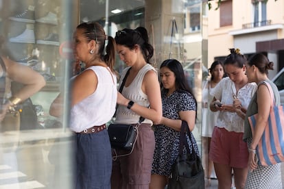 Varias personas hacen cola para entrar a la zapatería, este sábado.