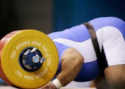 Hossein Rezazadeh sumerge su rostro entre las pesas tras conseguir una victoria con plusmarca mundial incluida.