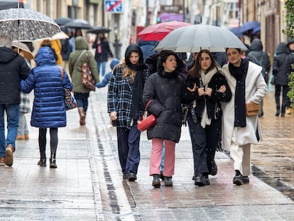 Varias personas pasean con paraguas y muy abrigados en la calle Portales de Logroño, el pasado domingo.
