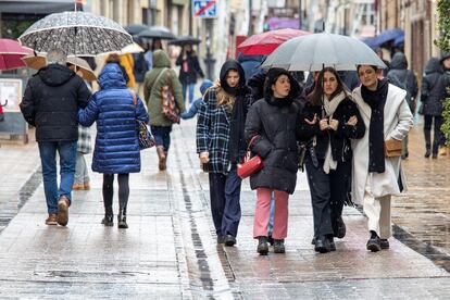 Varias personas pasean con paraguas y muy abrigados en la calle Portales de Logroño, el pasado domingo.