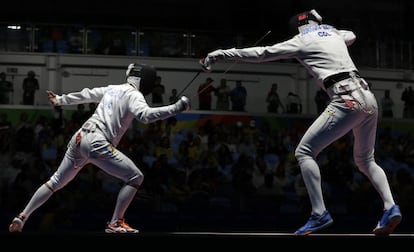 Dmytro Karyuchenko, de Ucrania (izquierda), y John Edison Rodríguez, de Colombia, compiten en la prueba inididual de esgrima.