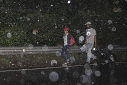 Migrantes venezolanos caminan bajo fuertes lluvias por una carretera en el Norte de Santander, Colombia. Noviembre de 2020.