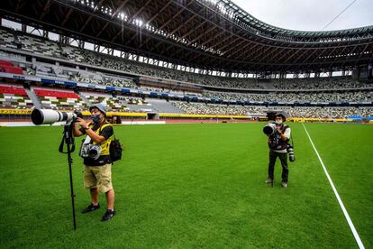 Dos fotógrafos se preparan este domingo para captar imágenes de la competición de salto de altura para hombres, en el Estadio Nacional de Japón.
