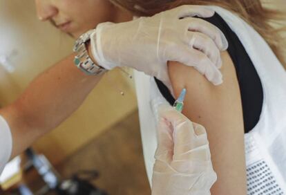 Un sanitario vacuna a una joven. 
