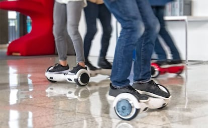 Dos usuarios montan en 'hoverboard', un vehículo parecido al Segway pero sin manillar.