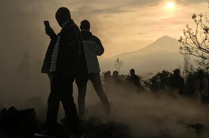 Un vecino usa su teléfono móvil para tomar fotografías de las casas destruidas por la lava, que aún siguen humeantes, cerca de Goma (República del Congo), este domingo.