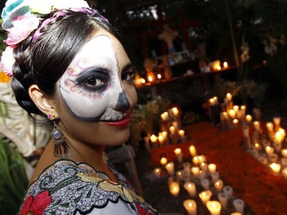 Las familias colocan velas sobre las tumbas de sus familiares para  iluminar el camino de las &aacute;nimas en su vuelta a casa.