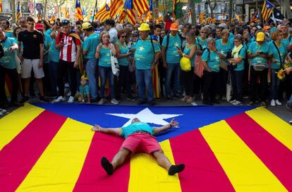 Un hombre se tumba sobre una 'estelada', en la manifestación en Barcelona.