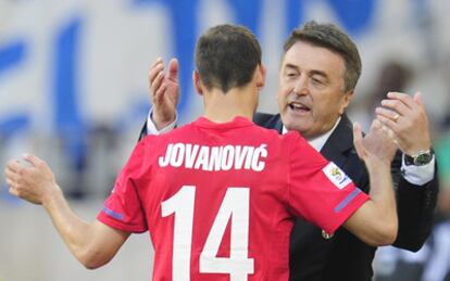 Milan Jovanovic choca sus manso con el entrenador serbio Radomir Antic al tiempo que abandona el terreno de juego.