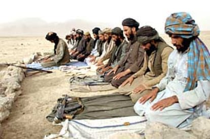 Guerreros talibanes rezan junto a una carretera en Chokar Karez, 80 kilómetros al norte de Kandahar.