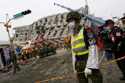 Varios edificios, entre ellos un bloque de viviendas de 16 plantas, se derrumbaron en la ciudad de Tainan por el sismo, que golpeó a las 03.57 hora local (20.57 del viernes hora española) mientras los residentes dormían. En la imagen, un soldado monta guardia frente a un edificio derrumbado en Tainan, al sur de Taiwán.
