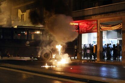 Agentes de la policía antidisturbios se protegen del lanzamiento de cócteles molotov por parte de los manifestantes.