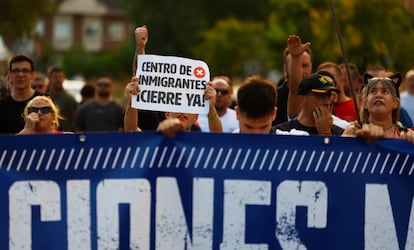 Un joven sostiene una pancarta pidiendo el cierre del centro de inmigrantes en Alcalá de Henares.