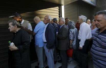 Dozens of Greek pensioners standing in line in front of a bank in Athens to collect their checks.