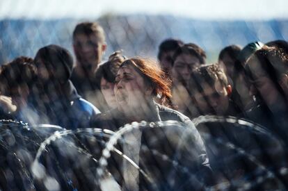 Una mujer protesta junto a otros migrantes tras una valla en la frontera entre Grecia y Macedonia, cerca de Gevgelija (Macedonia), el 2 de marzo de 2016.