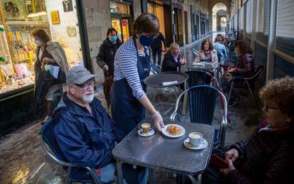 Una pareja toma un café en una terraza del centro de San Sebastián.