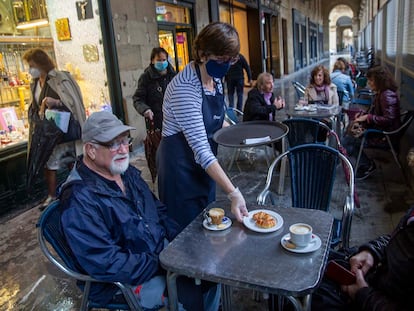 Una pareja toma un café en una terraza del centro de San Sebastián.
