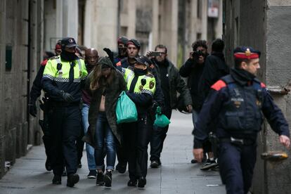 Agentes de los Mossos d'Esquadra custodian a los detenidos hasta los vehiculos policiales.