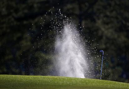 El inglés Luke Donald saca la bola del búnker en el 18.