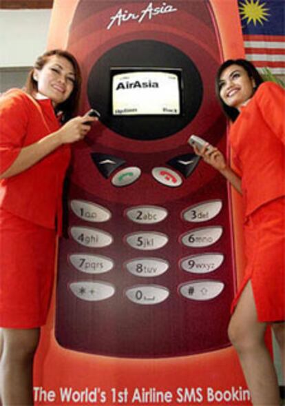Dos azafatas de Air Asia en la presentación del nuevo sistema de la compañía para vender billetes por mensajes cortos