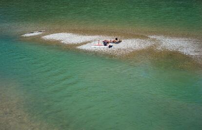 Dos personas toman el sol en un pedazo de gravilla en el ro Isar, en Mnich (Alemania).