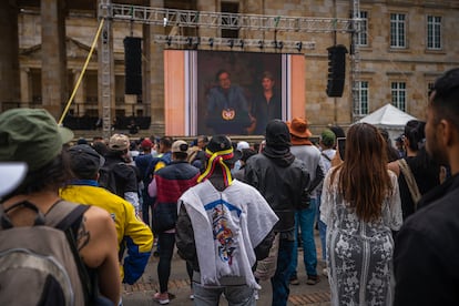 Asistentes a la marcha del Primero de Mayo, ven el discurso de Gustavo Petro desde una pantalla en la Plaza de Bolívar.