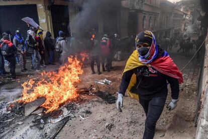 Un manifestante pasa al lado de una barricada, durante una nueva jornada de disturbios, en Quito (Ecuador). 