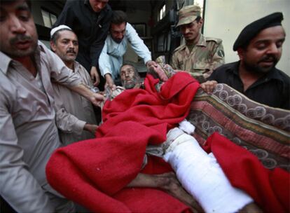 Policías y personal sanitario trasladan a un hospital de Peshawar a un herido en el ataque de Shangla.