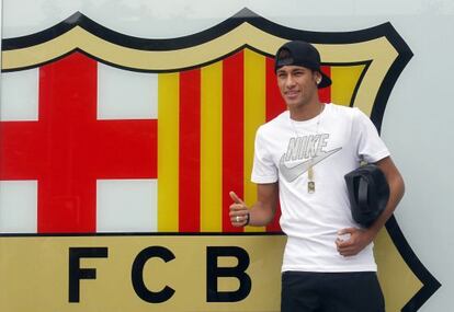 Brazilian soccer player Neymar poses for the media in front of Barcelona's offices, close to Camp Nou stadium in Barcelona June 3, 2013.
