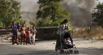 Un grupo de habitantes del Gallinero mira un incendio de basuras en el poblado.