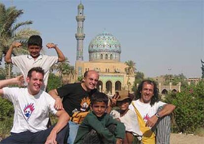 Maximiliano Stia, Viyuela y Casali (de izquierda a derecha), junto a niños de la calle en Bagdad.