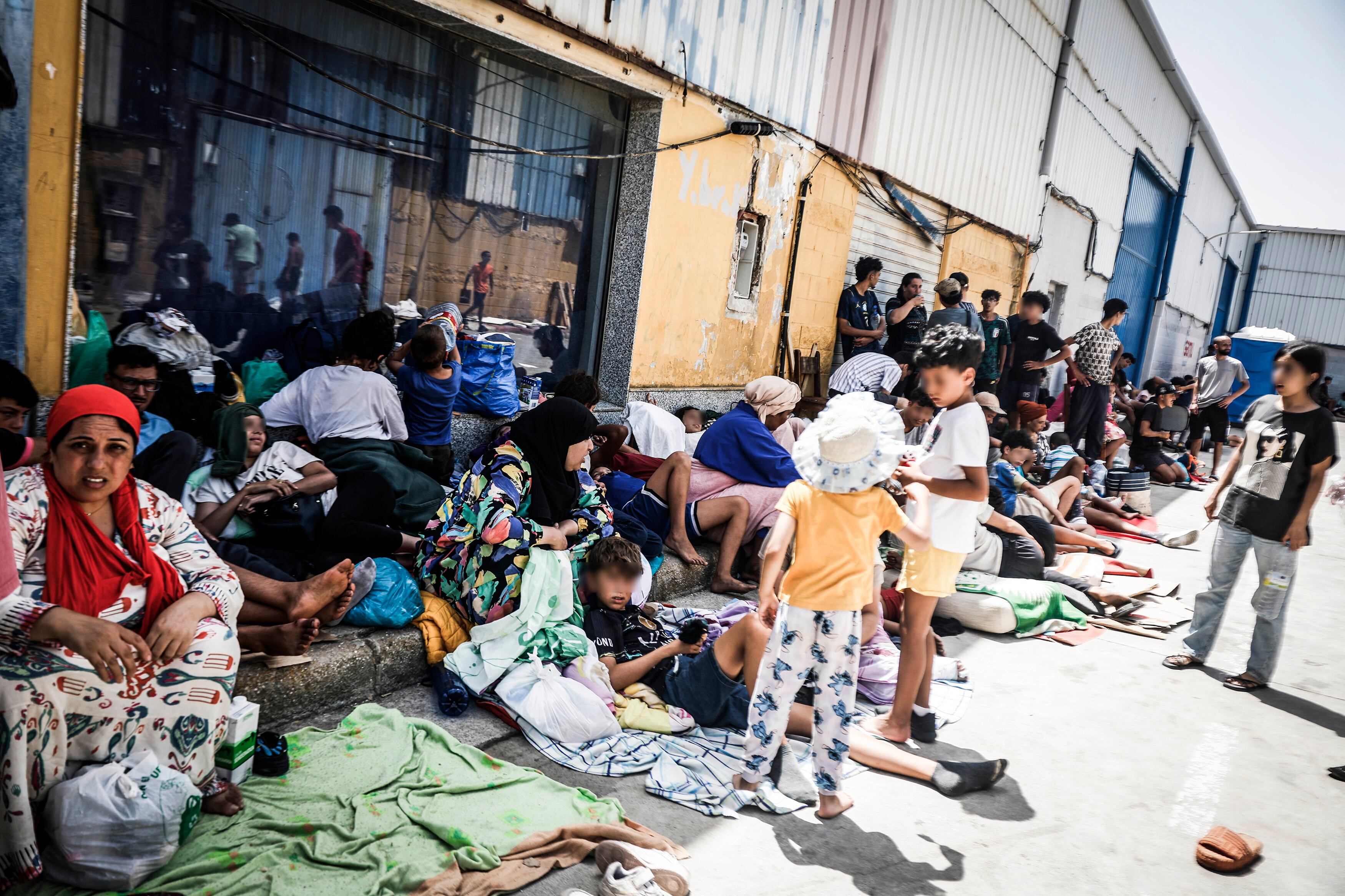 Migrantes, entre ellos menores, duermen en las calles de un poligono de Ceuta cercano a la frontera.