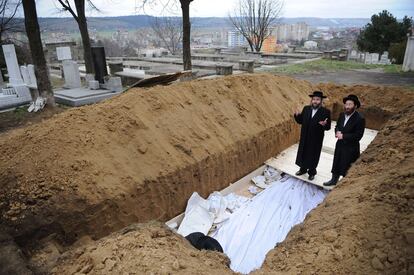 Dos rabinos rezan en la fosa donde descansan los 40 judíos asesinados en  Popricani.