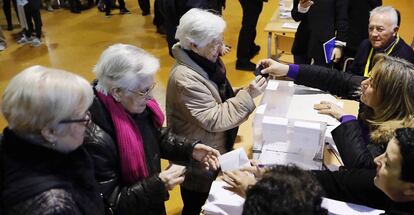 Tres hermanas ancianas acuden juntas a votar en la Escola Pere IV de Barcelona, ayer.